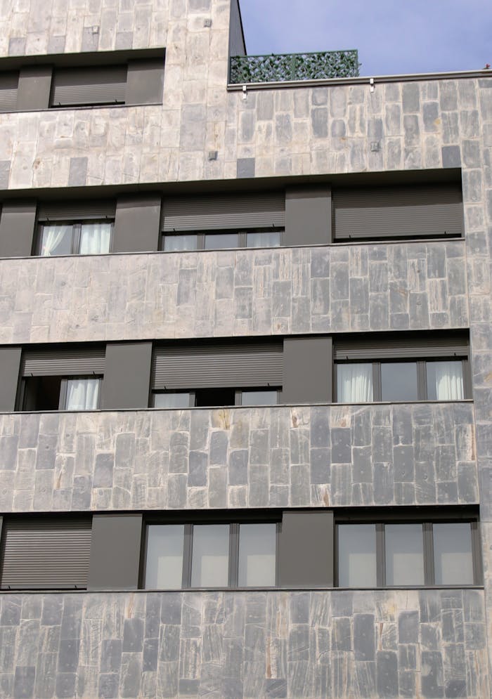 Services Close-up of a contemporary apartment building facade with multiple windows.