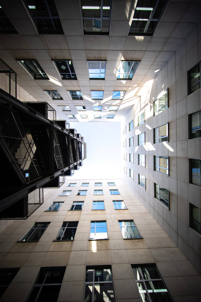 Services Low angle view of modern buildings with a bright sky, highlighting urban architectural style.