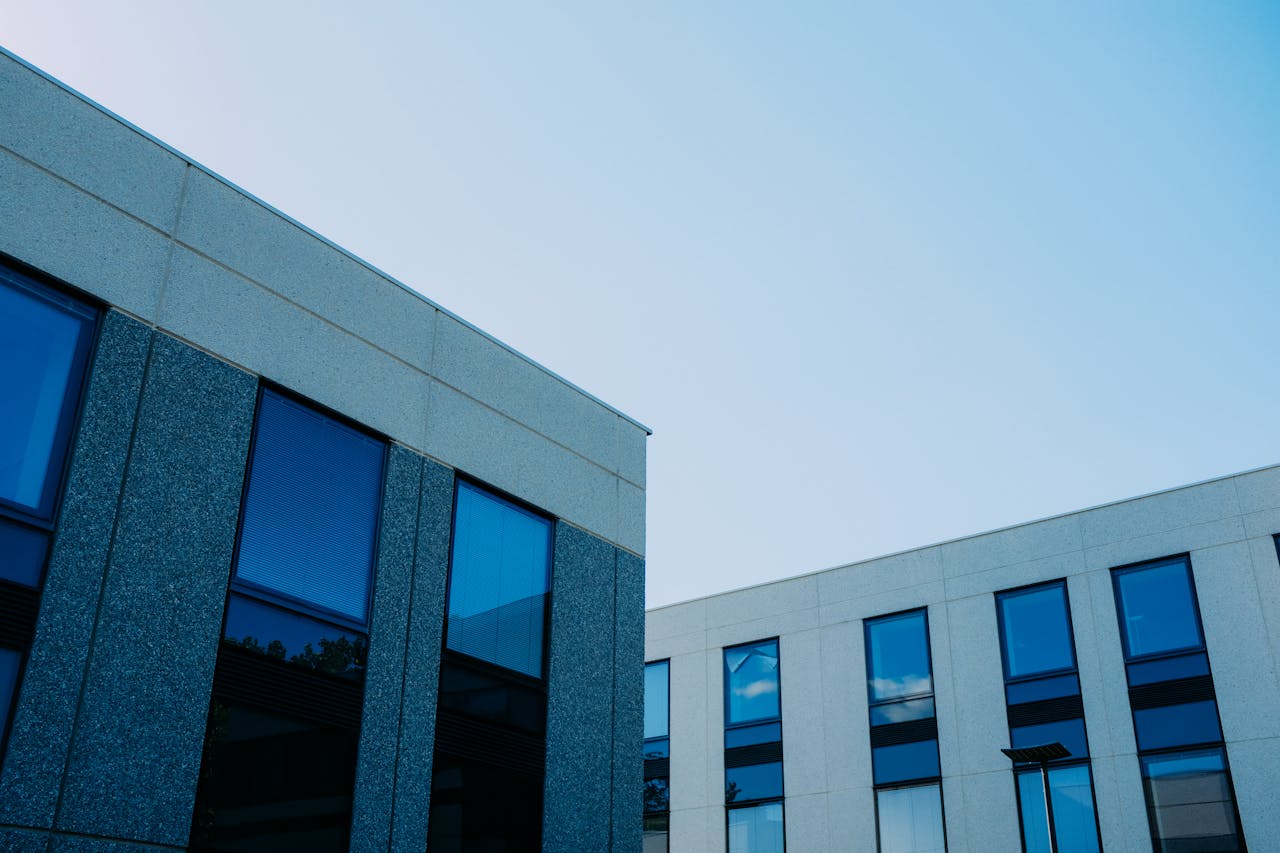 Home From below of contemporary office buildings with reflection in windows located in city