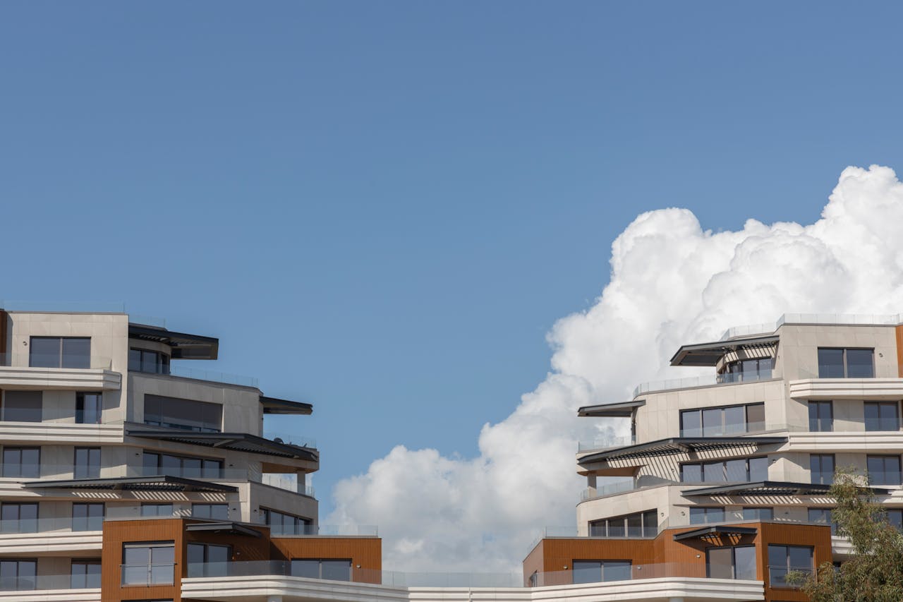 Home Contemporary urban architecture under a bright blue sky with clouds.
